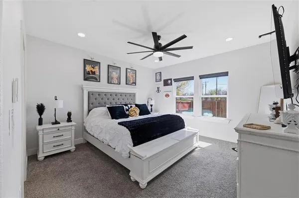 a spacious bedroom with a bed and a ceiling fan