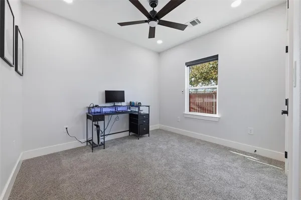 an empty room with a window and a fan