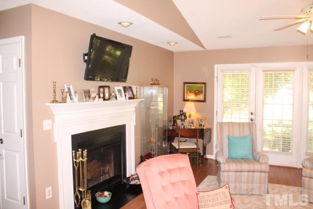 2707 Cottage Circle Raleigh, NC 27613 - Photo 4 of 21 a living room with furniture a flat screen tv and a fireplace