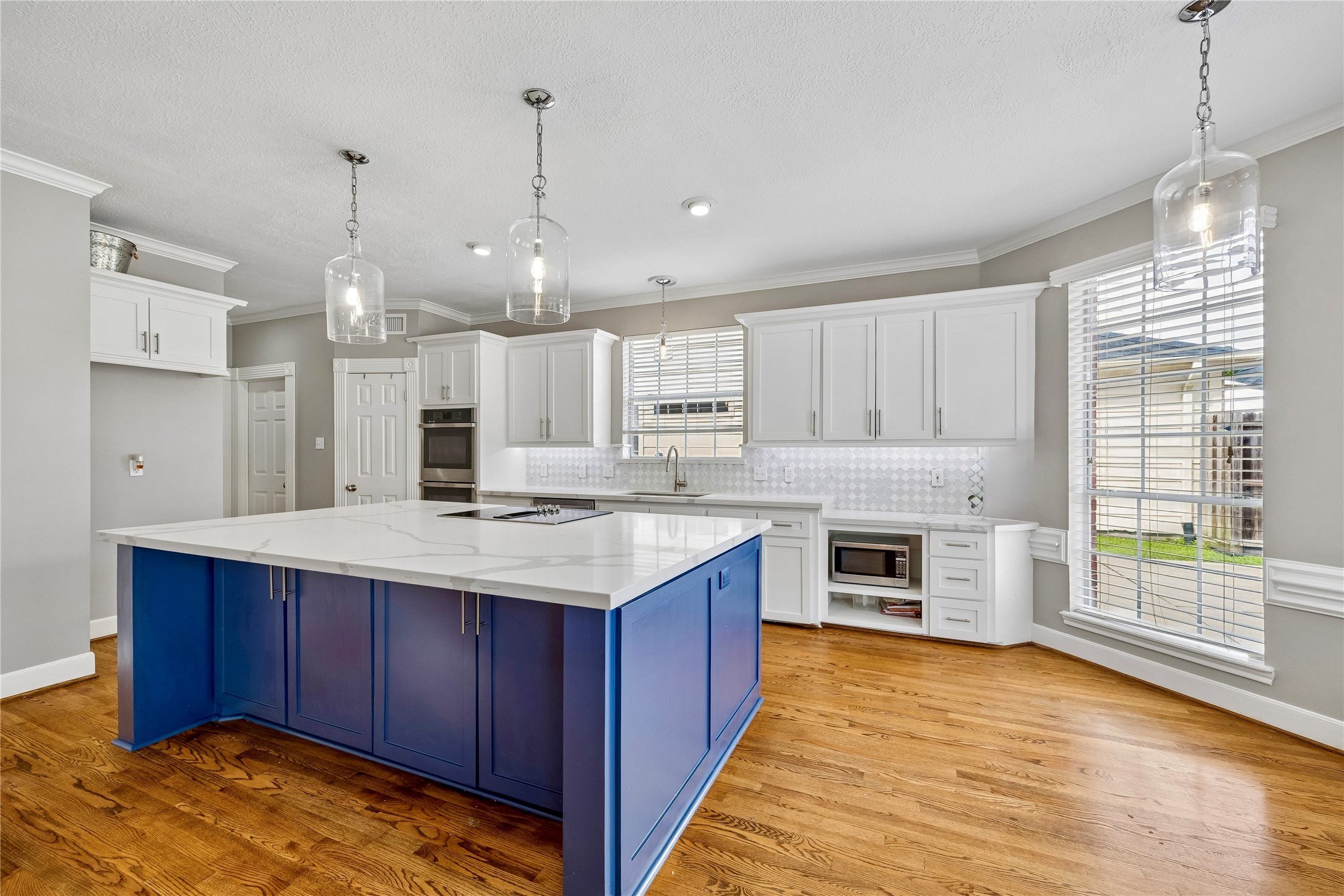 7915 Huddersfield Court Spring, TX 77379 - Photo 16 of 37 Fully updated kitchen with a large island, quartz-style counters, pendant lighting, white cabinetry, modern backsplash, and abundant storage for everyday cooking and entertaining.