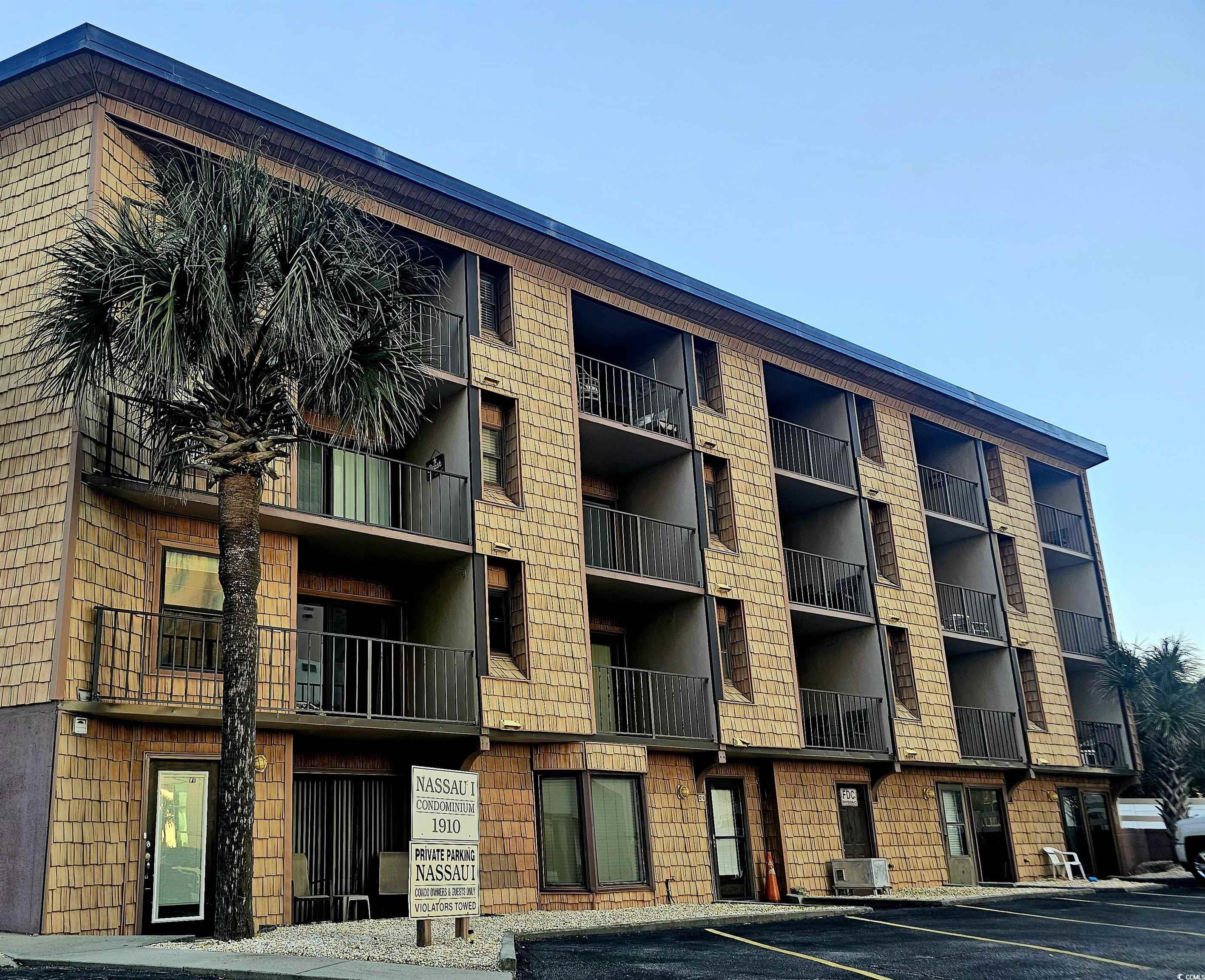 View of apartment building / complex with uncovered parking