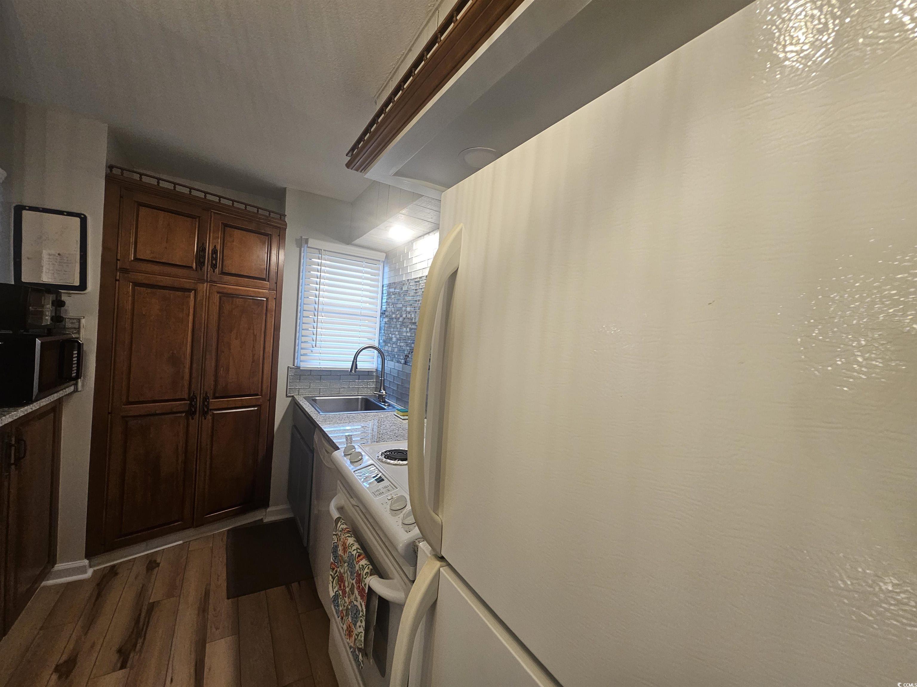 1910 South Ocean Boulevard, Unit C2 NASSAU I North Myrtle Beach, SC 29582 - Photo 6 of 12 Kitchen featuring white appliances and dark wood-style flooring