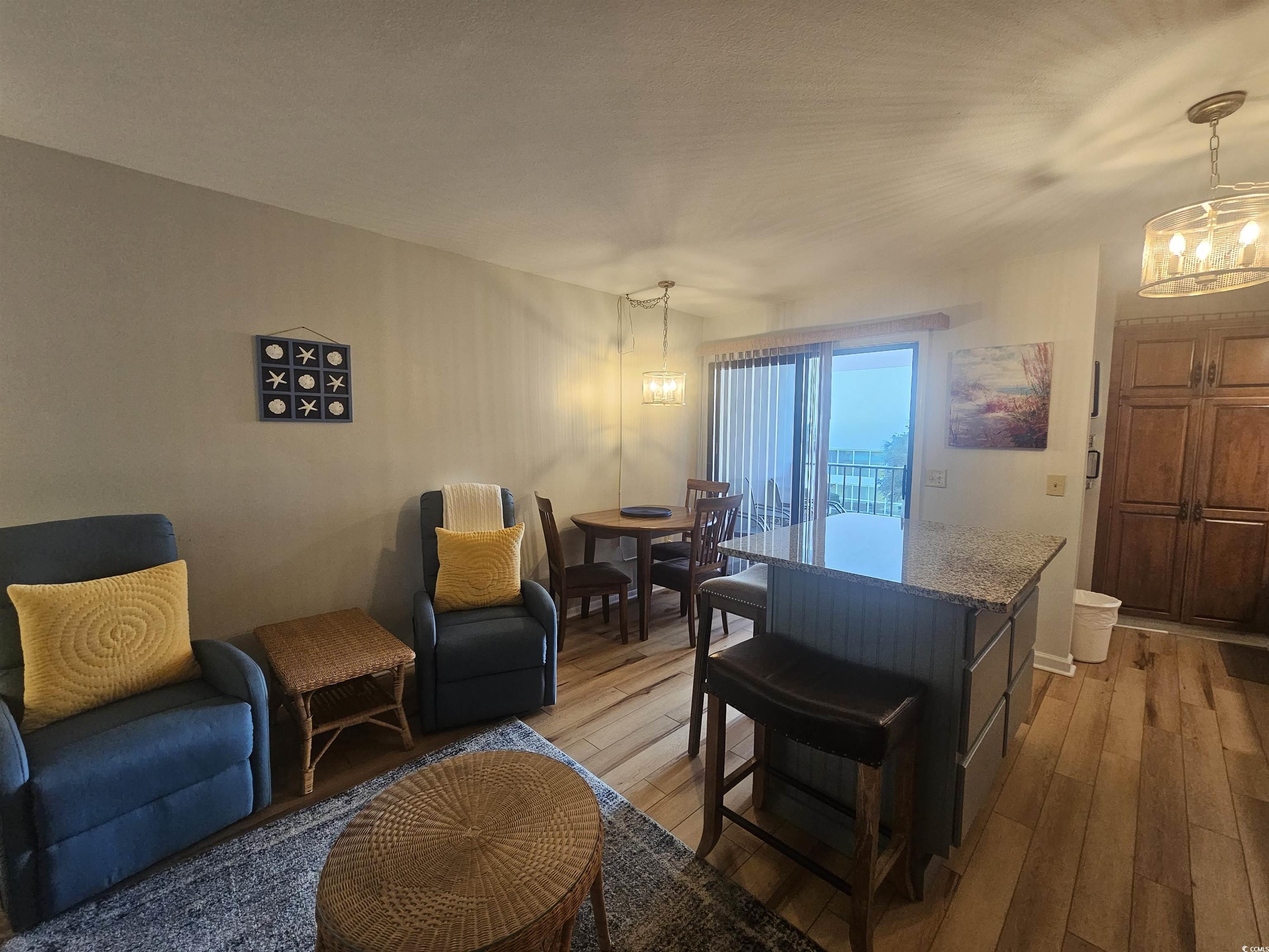 1910 South Ocean Boulevard, Unit C2 NASSAU I North Myrtle Beach, SC 29582 - Photo 9 of 12 Living area featuring a chandelier and light wood-style flooring