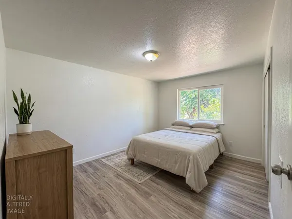 a bedroom with a bed and a potted plant on dresser