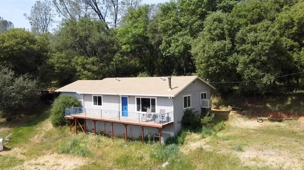 an aerial view of a house with swimming pool next to a big yard