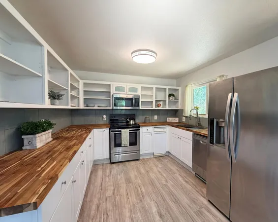 a kitchen with stainless steel appliances a refrigerator and a stove top oven
