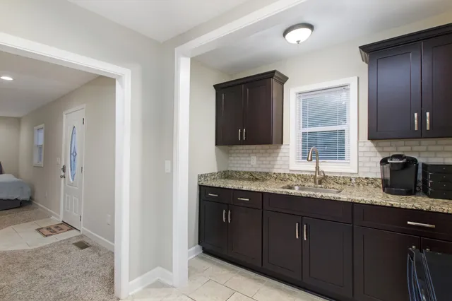 a bathroom with a granite countertop double vanity sink and mirror
