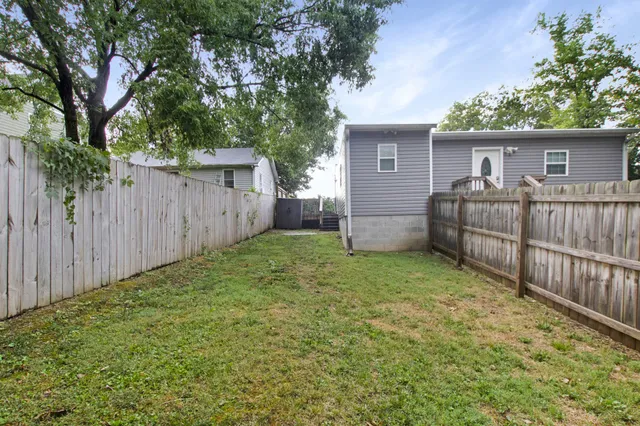 a view of a house with a yard and wooden fence
