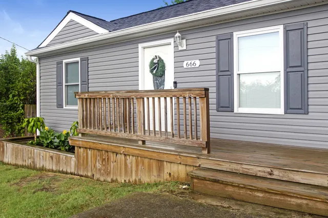 a view of a house with a small yard and wooden floor and fence
