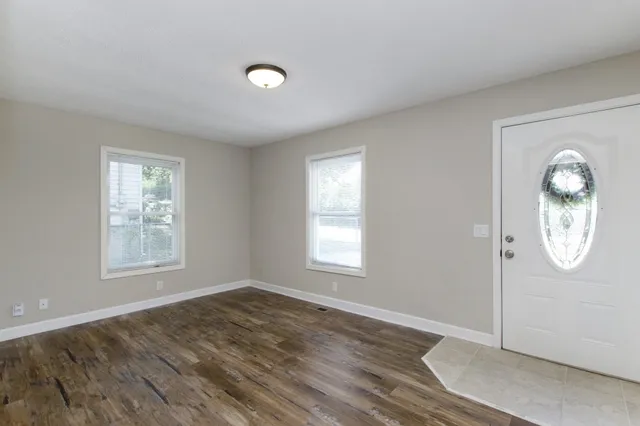 an empty room with window mirror and windows