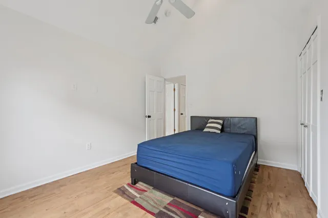 a room with a bed and a chandelier fan