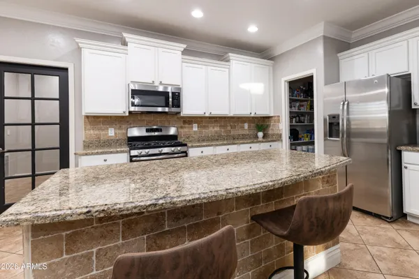 a kitchen with stainless steel appliances granite countertop a sink refrigerator and microwave