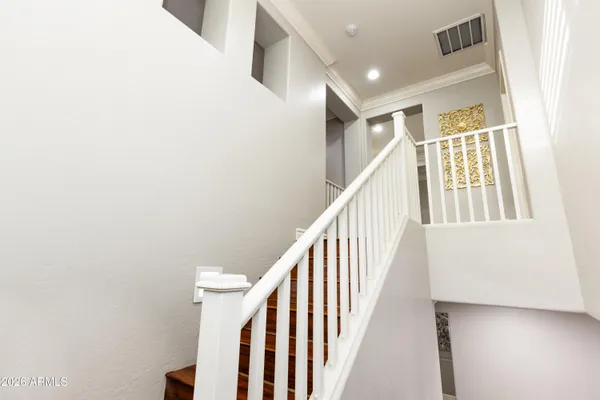 a view of staircase with lots of frames on wall and a window