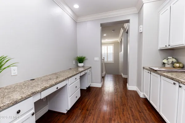 a kitchen with granite countertop white cabinets and wooden floor