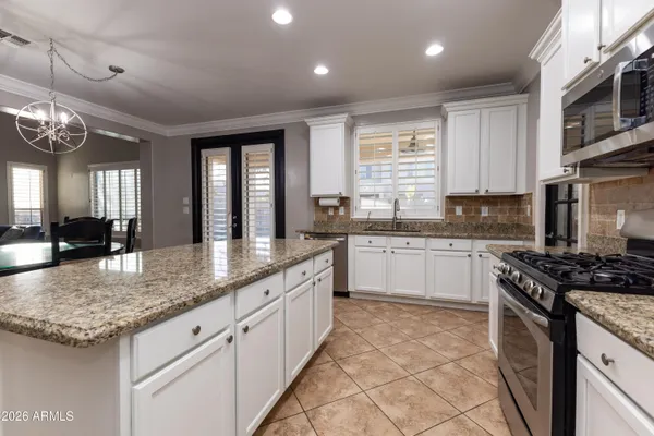 a kitchen with granite countertop stainless steel appliances a stove sink and microwave
