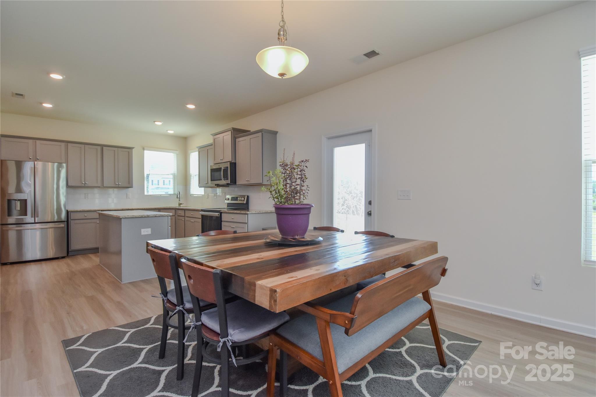 139 West Neel Ranch Road Mooresville, NC 28115 - Photo 11 of 40 a kitchen with a dining table chairs and refrigerator