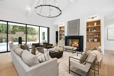 a living room with furniture a fireplace and a large window with balcony view