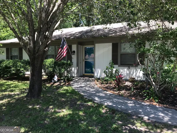 a view of a house with a tree in front of it