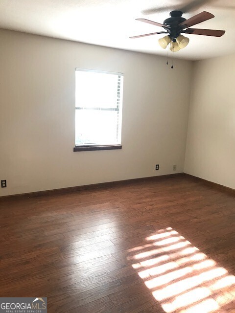 390 Powderhorn Road St. Marys, GA 31558 - Photo 12 of 18 an empty room with wooden floor fan and windows