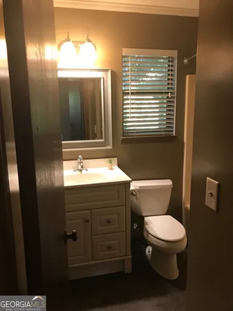 a bathroom with a toilet sink and mirror