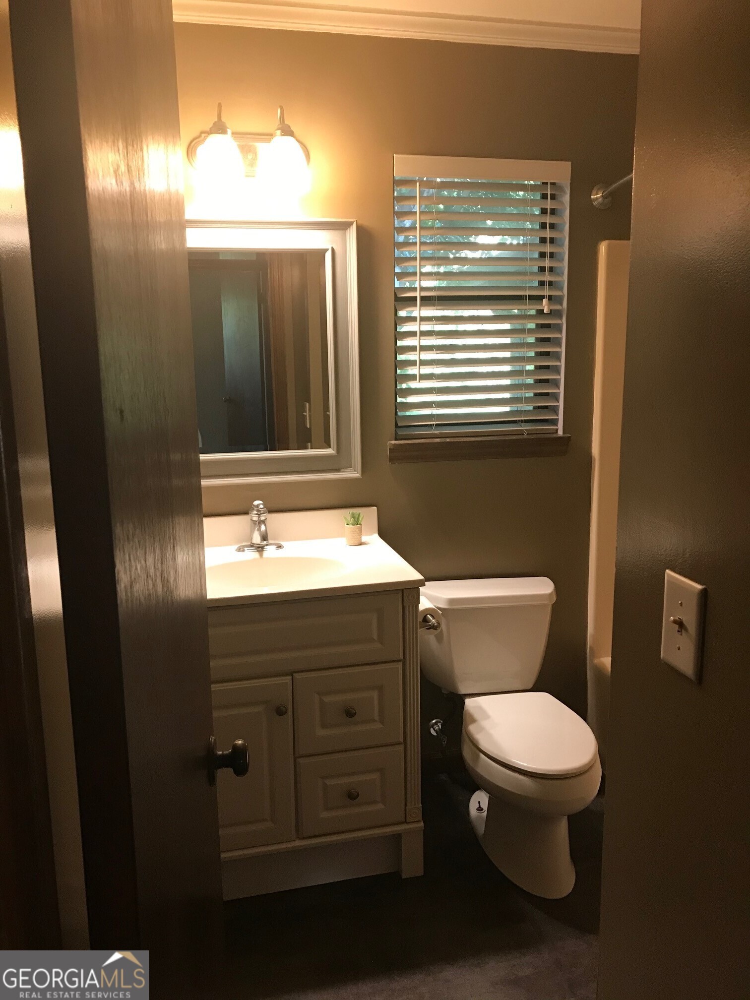 390 Powderhorn Road St. Marys, GA 31558 - Photo 13 of 18 a bathroom with a toilet sink and mirror