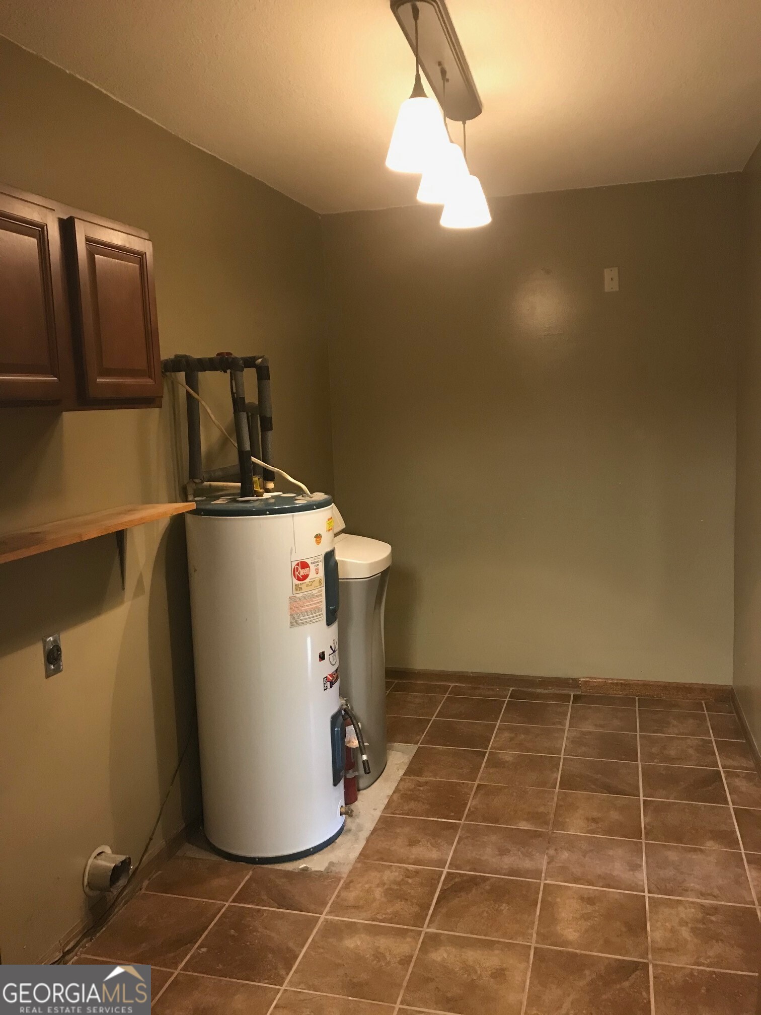 390 Powderhorn Road St. Marys, GA 31558 - Photo 16 of 18 a utility room with water heater and refrigerator
