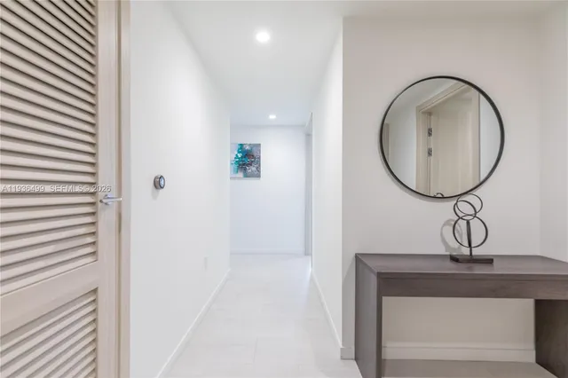 a living room with furniture a flat screen tv and kitchen view