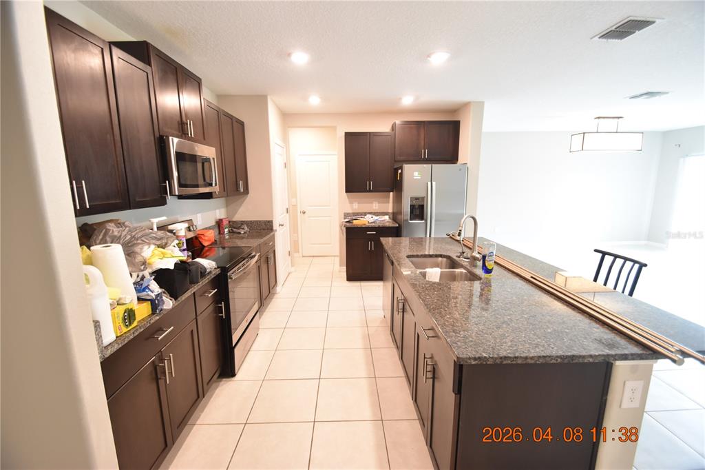 2187 Old Mining Road Lakeland, FL 33801 - Photo 16 of 65 a kitchen with stainless steel appliances granite countertop a sink stove and refrigerator