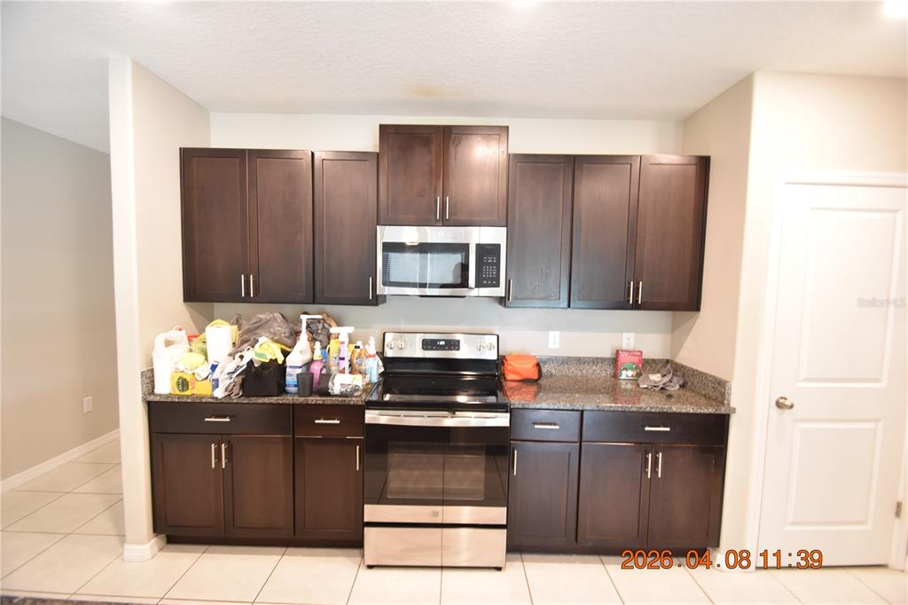 2187 Old Mining Road Lakeland, FL 33801 - Photo 17 of 65 a kitchen with stainless steel appliances granite countertop wooden cabinets and stove top oven