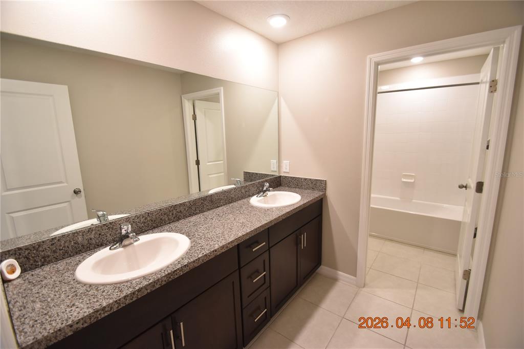 2187 Old Mining Road Lakeland, FL 33801 - Photo 56 of 65 a bathroom with a granite countertop sink a mirror and a bathtub