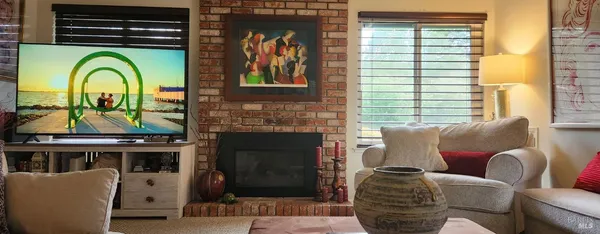 a living room with furniture a fireplace and a window