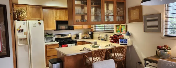 a view of a dining room with furniture a kitchen and chandelier