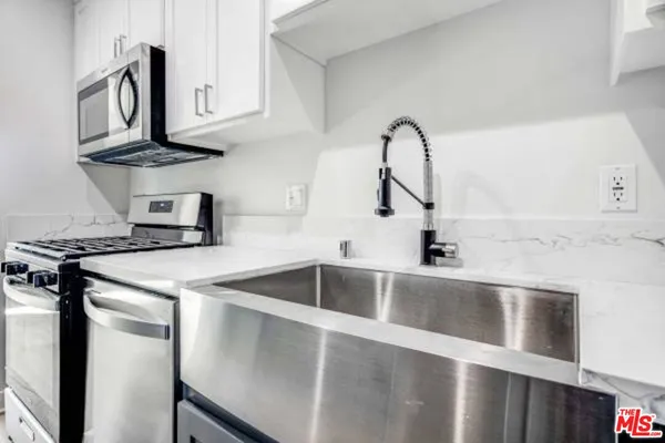 a kitchen with stainless steel appliances granite countertop a sink and a microwave