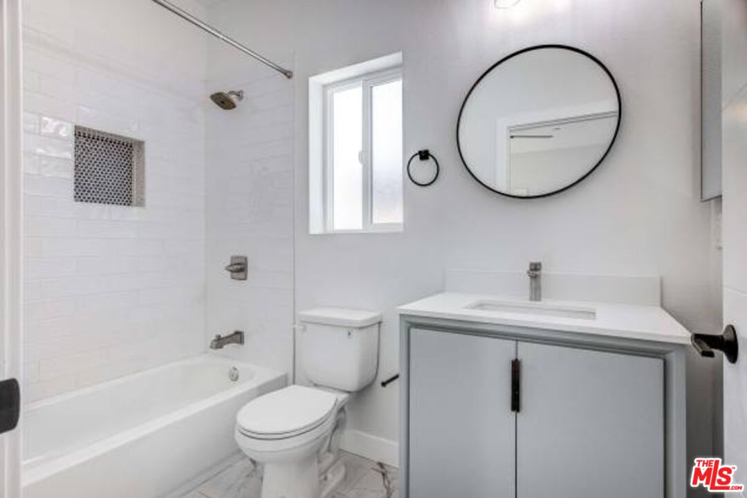 624 West 83rd Street, Unit 624 1/4 Los Angeles, CA 90044 - Photo 3 of 5 a bathroom with a toilet a sink and a mirror