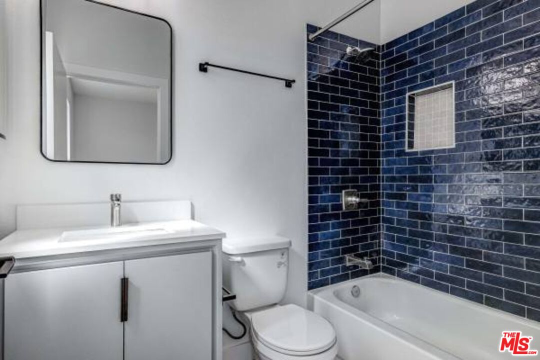 624 West 83rd Street, Unit 624 1/4 Los Angeles, CA 90044 - Photo 5 of 5 a bathroom with a toilet sink vanity tub and mirror