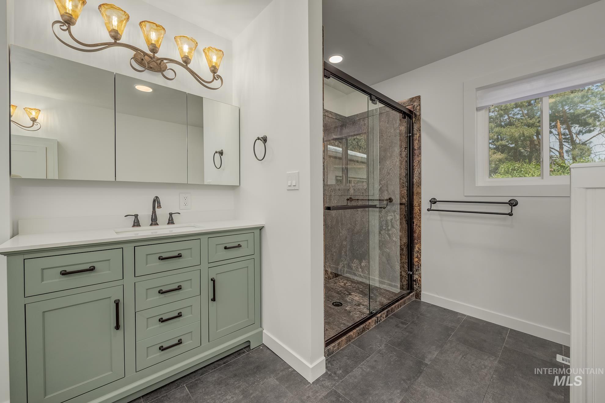 748 Pringle Road Weiser, ID 83672 - Photo 16 of 47 Bathroom featuring a sage green vanity with black hardware, white countertop, and a built-in sink