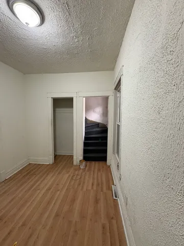 a view of a hallway with wooden floor and closet