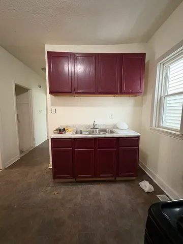a view of kitchen with granite countertop wooden cabinets