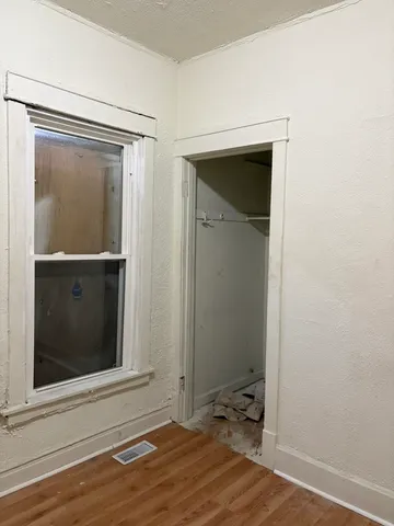 a view of a small space with wooden floor and a window