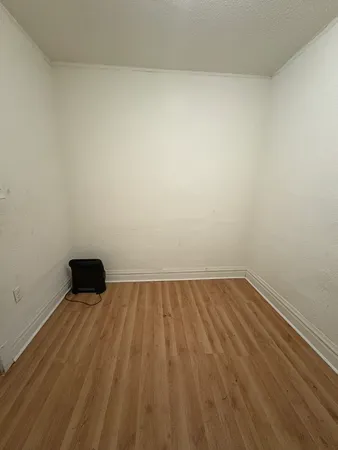 a view of a room with an empty space and wooden floor