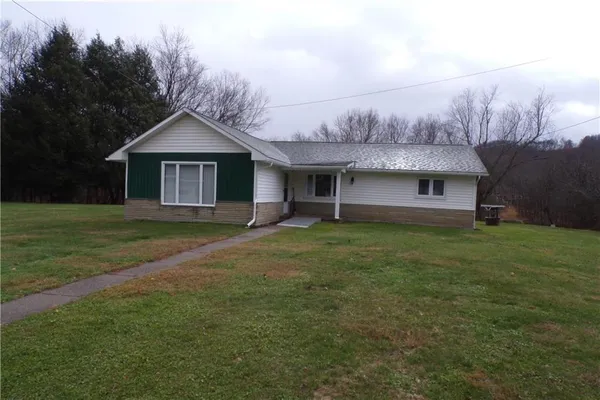 a front view of a house with a garden and yard