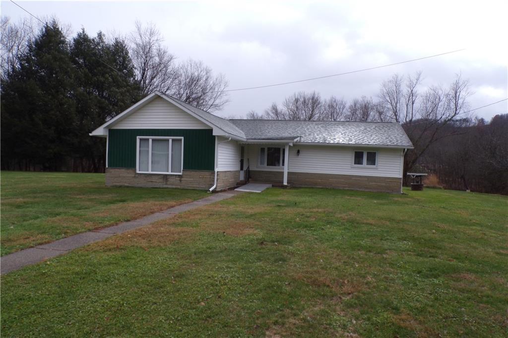 a front view of a house with a garden and yard