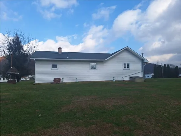 a view of backyard of house with green space