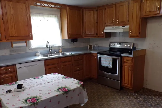 a kitchen with a sink a stove and cabinets