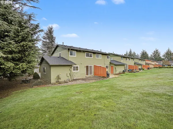 a front view of house with yard and trees in the background