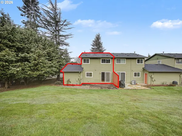 a front view of house with yard and trees in the background
