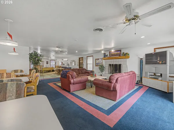 a living room with furniture a flat screen tv and kitchen view