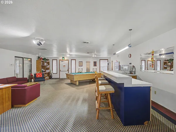 a living room with furniture a flat screen tv and gym equipment