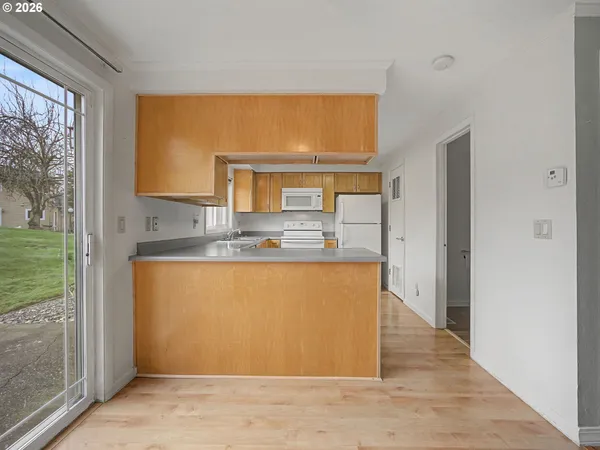 a view of kitchen with stainless steel appliances granite countertop a refrigerator and a sink