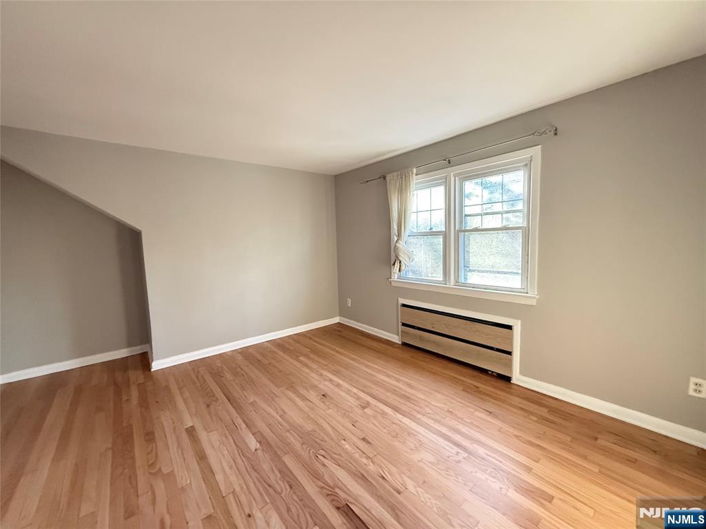 175 Van Winkle Street, Unit 2 East Rutherford, NJ 07073 - Photo 13 of 20 an empty room with wooden floor and windows